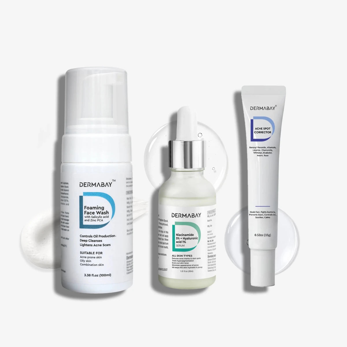 Flatlay product shot of the Dermabay Anti Acne Combo featuring the Foaming Face Wash, Niacinamide Serum 5% + Hyaluronic Acid 1%, and Acne Spot Corrector with texture swatches.